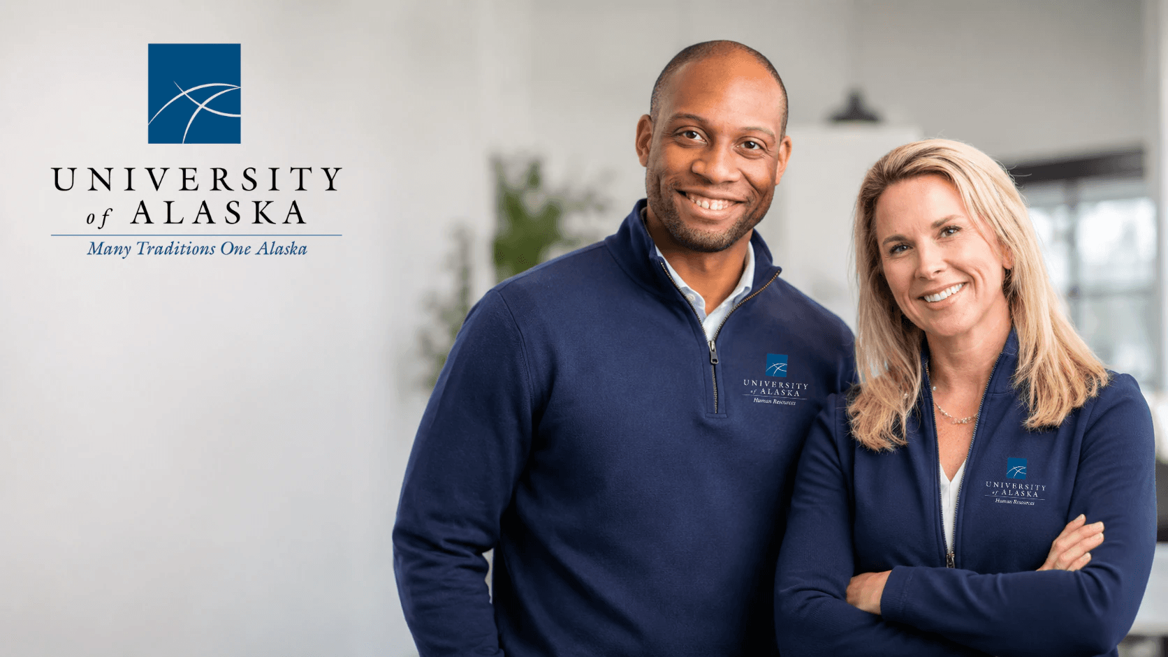 Two University of Alaska Human Resources colleagues in navy branded pullovers